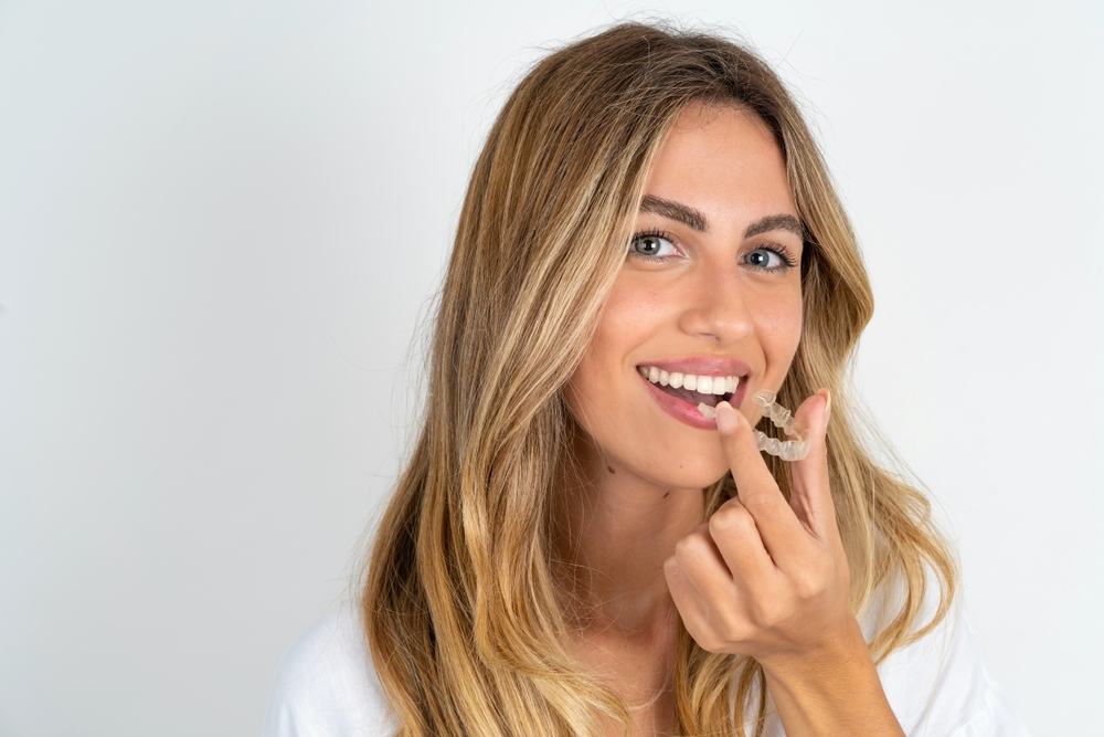 Woman putting in an Invisalign aligner.