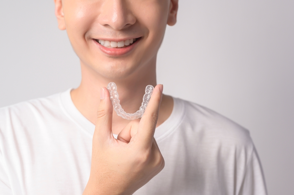 Man holding an Invisalign set.